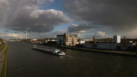 A-freight-goes-down-the-canal-past-windmills-in-Albertkanaal