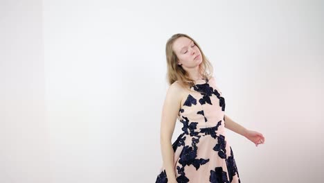 young woman in pink floral dress posing against white background