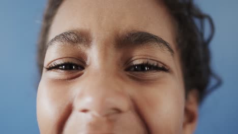 portrait of happy african american girl on blue background, slow motion