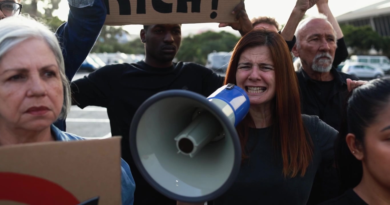 Donna che urla nel megafono durante una manifestazione di protesta