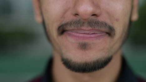 primer plano de la boca de un hombre de raza mixta mirando a la cámara, sonriendo