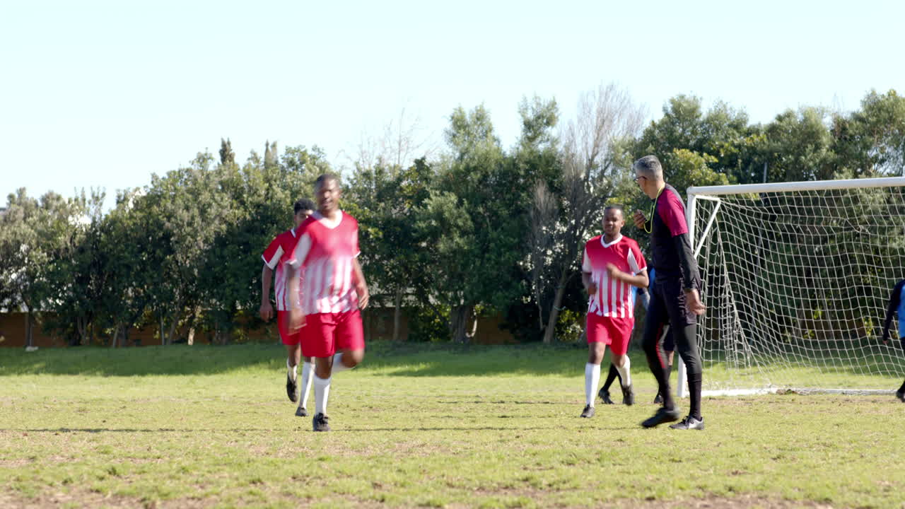 Playing soccer, team running on field towards goal during practice session