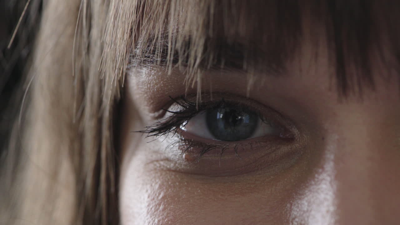 mujer caucásica de ojo azul parpadeando mirando a la cámara sonriendo feliz