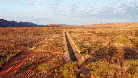 open road through the red landscape of alice springs in australia -aerial