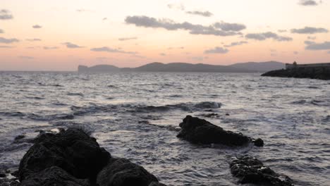 puesta de sol desde la playa de la costa en alghero en la isla de cerdeña