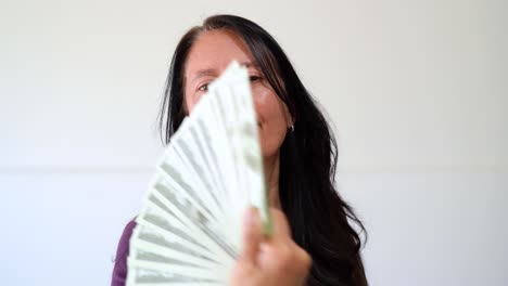 woman fanning out money - display of wealth. - closeup shot