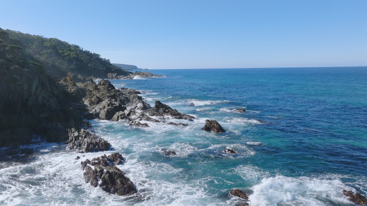Aereo: Drone che aggira una scogliera per rivelare altra costa rocciosa, Costa Sud NSW, Australia