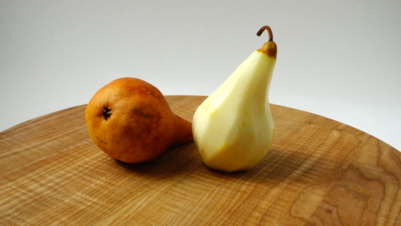 Pere su un tagliere di legno in cucina. Ripresa in movimento