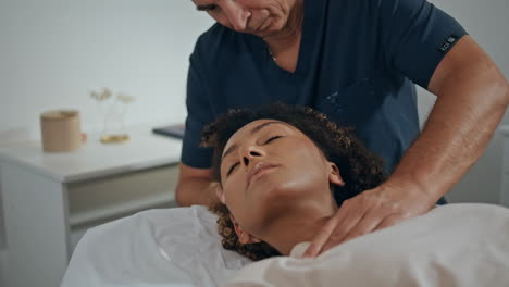 physician doing manual massage in health clinic. closeup patient face