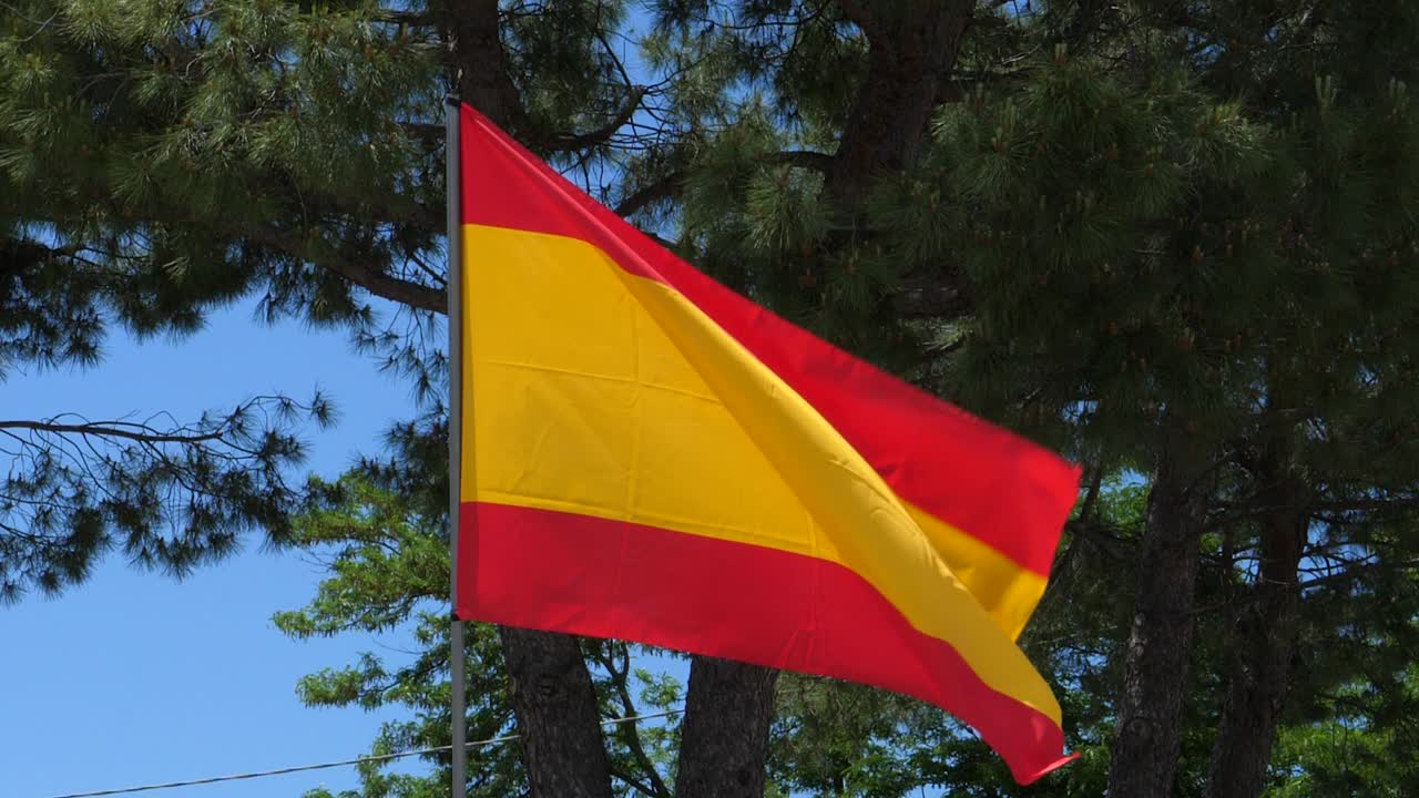 bandera de españa ondeando en el viento en cámara lenta cerca con el fondo del cielo