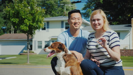 Feliz-Familia-Multiétnica-Con-Un-Perro-En-El-Contexto-De-Un-Nuevo-Hogar-Tiene-La-Llave-En-La-Mano