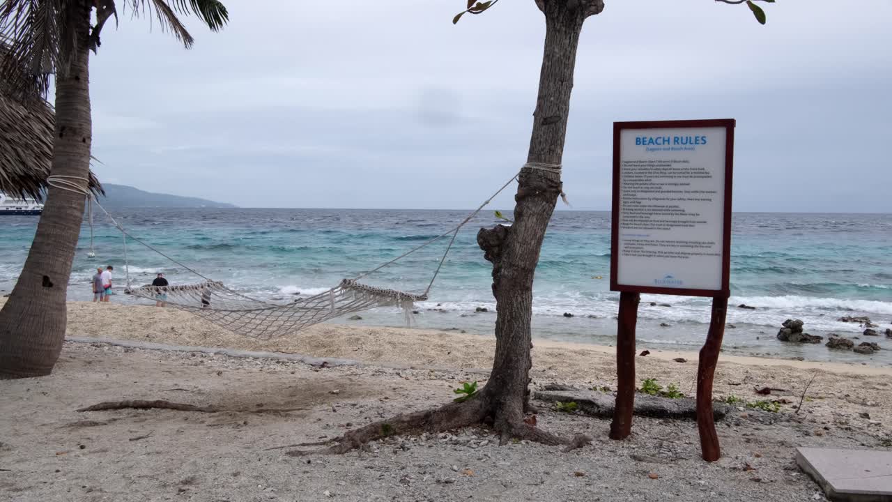 reglas de playa y hamacas colgando de los árboles en la isla tropical de sumilon en cebu, filipinas