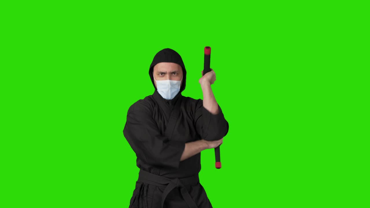 video de un hombre en traje negro ninja con nunchucks