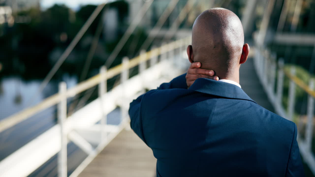 hombre de negocios con dolor de cuello en un puente