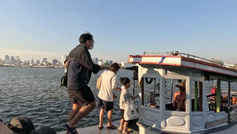 people getting on and off a small ferry boat