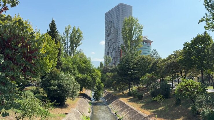 Rua Arborizada da Cidade de Tirana, Albânia, com Tráfego e Edifícios Urbanos nos Balcãs