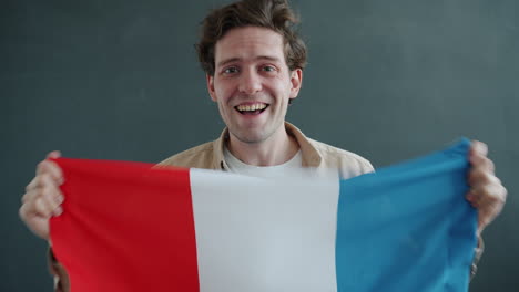 man holding french flag with excitement