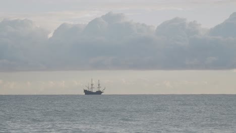 корабль-реплика галеона "андалусия" 16 века, плывущий вдали в средиземном море в прекрасный облачный день на восходе солнца