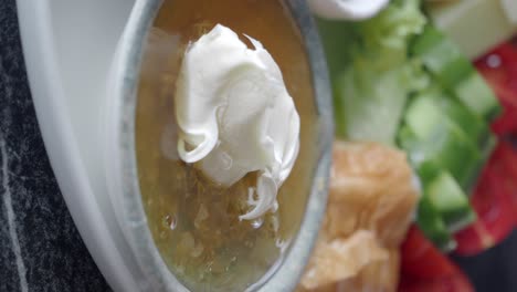 close-up of a bowl of honey with cream, part of a breakfast spread