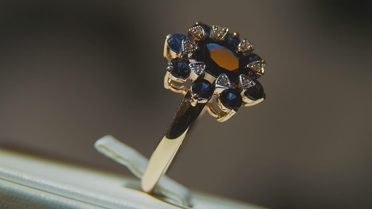 primer plano de un anillo de oro con zafiros y diamantes