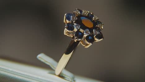 primer plano de un anillo de oro con zafiros y diamantes