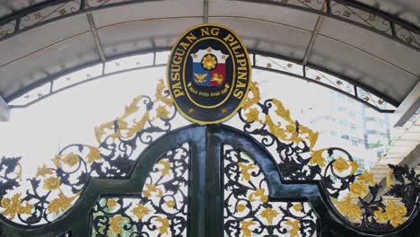 zooming out of the philippine embassy seal on top of the front gate of the consular building, located in sukhumvit street, bangkok, thailand