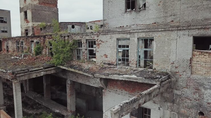 Vista aérea de edifícios industriais abandonados. Galpões de fábrica abandonados com vidros quebrados nas janelas.