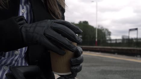 mujer de negocios con café para llevar en la estación de tren plano medio