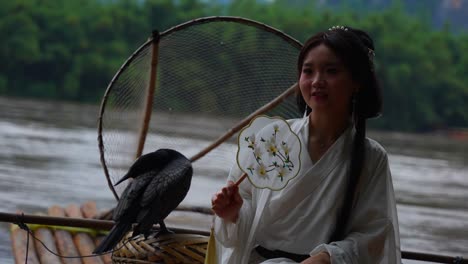 hanfu chinese girl with cormorants on a bamboo raft appearing a lantern