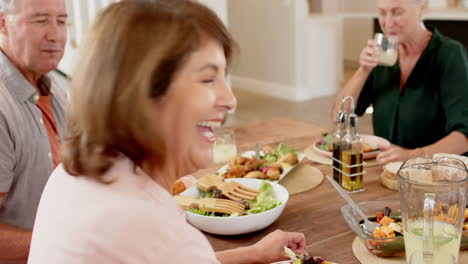 laughing woman enjoying meal with friends at dining table, sharing joyful moment