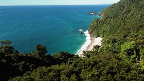 Belleza-De-La-Costa-Oeste-De-Nueva-Zelanda-Con-Altos-Acantilados-Cubiertos-De-Bosque,-Vista-Aérea