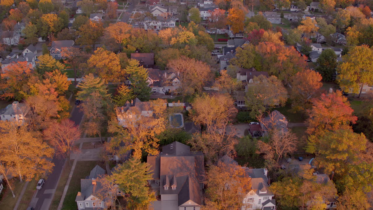 sobrevuelo aéreo hermosas casas y árboles coloridos en kirkwood, missouri a la hora dorada en otoño