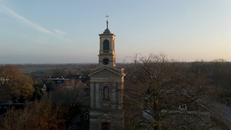 Ausleger-Der-Kirche-Hinter-Kahlen-Baum-Mit-Einer-Untergehenden-Sonne-Im-Hintergrund