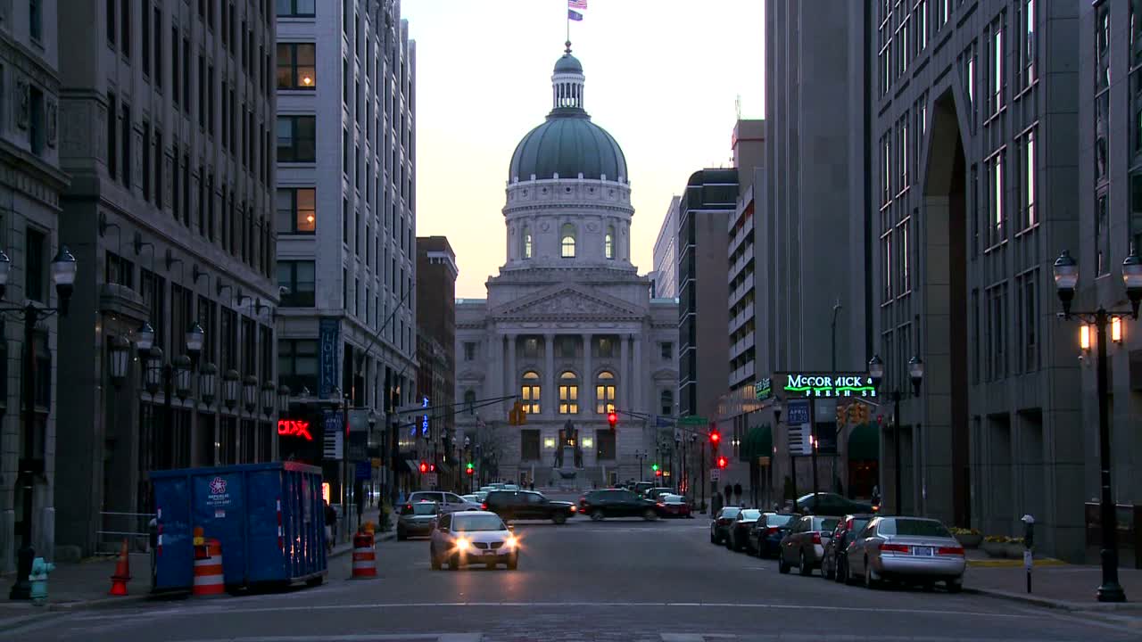 el tráfico pasa por el edificio de la capital del centro de indianapolis indiana