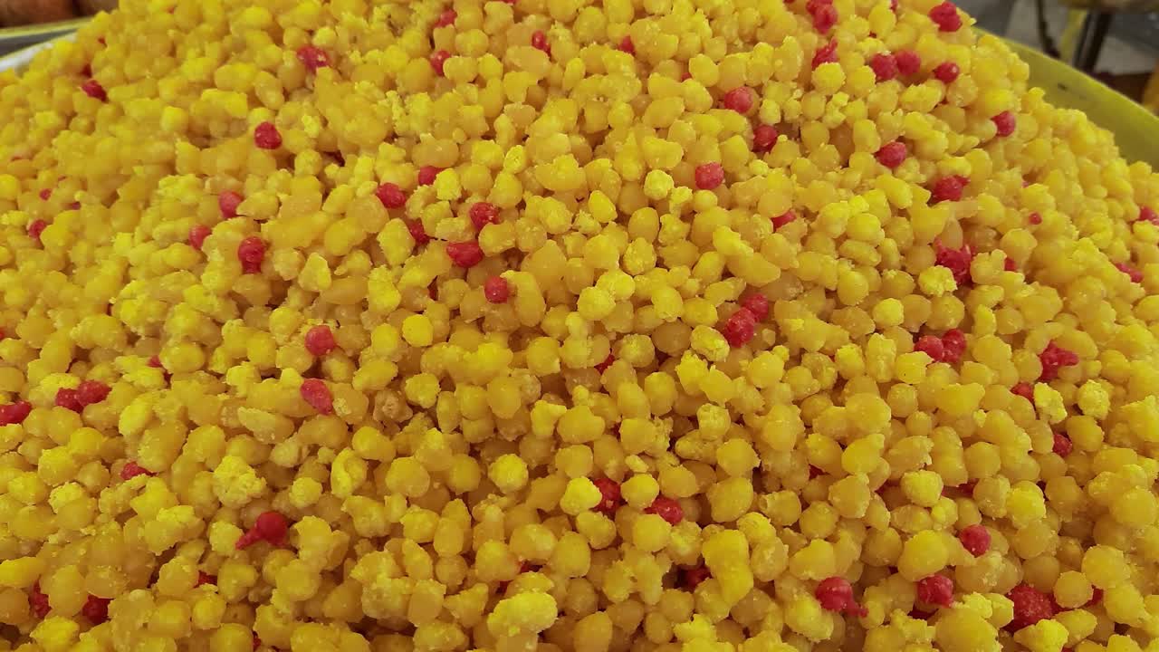 boondi로 알려진 인기 있는 인도의 다채로운 과자는 회색 배경에 제공됩니다.