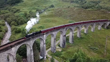 Toma-Aérea-Del-Tren-De-Vapor-Jacobite-Cruzando-El-Viaducto-De-Glenfinnan-En-Escocia