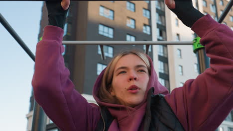 gym lover working out on horizontal pull up bar in urban park with autumn foliage showcasing forearm strength control and balance during intense calisthenics workout session