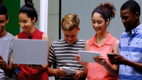 Students-using-laptop,-mobile-phone-and-digital-tablet