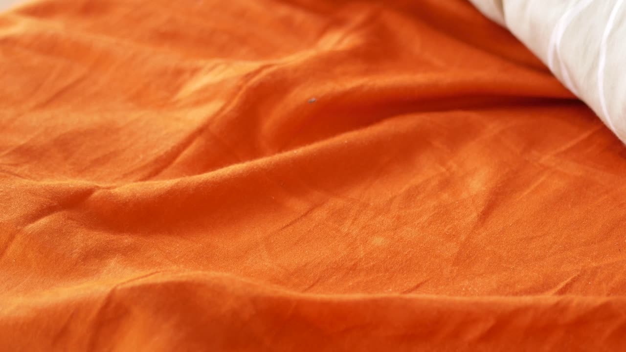 Closeup of an Orange Bed Sheet and Pillow