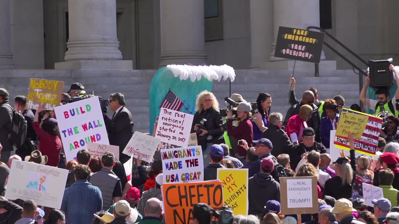 Trump supporter gets escorted off steps by police and crowd cheers. Med wide shot to wide then left pan.