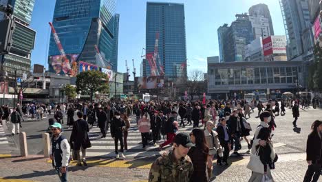 crowd of people walking across urban plaza