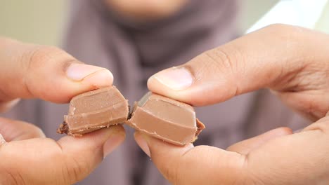 woman holding broken pieces of chocolate