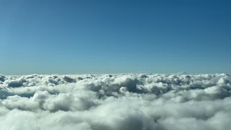 clouds scene, unique pilot’s view shot from an airplane cabin while flying over the clouds in a bright and sunny winter day