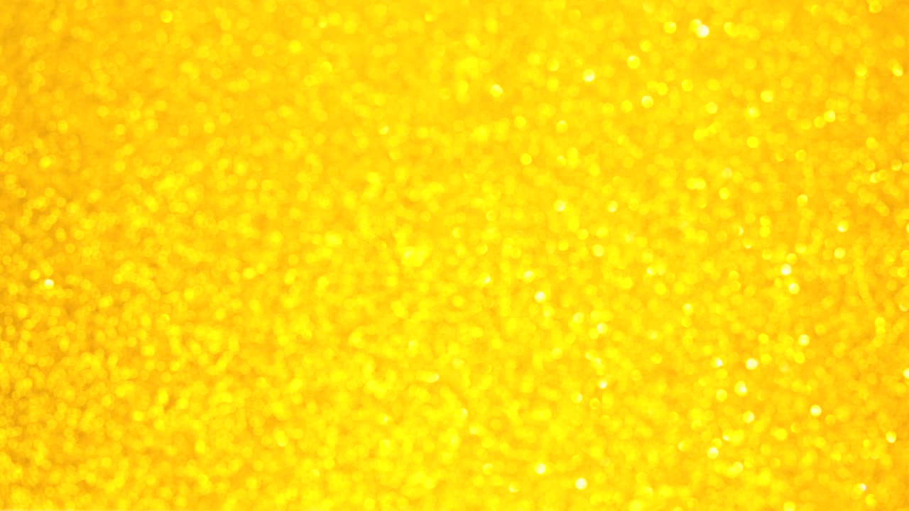 Sfondo astratto dorato decorativo sfocato con glitter scintillanti. Sfondo festivo e natalizio per testo. Filmato 4k