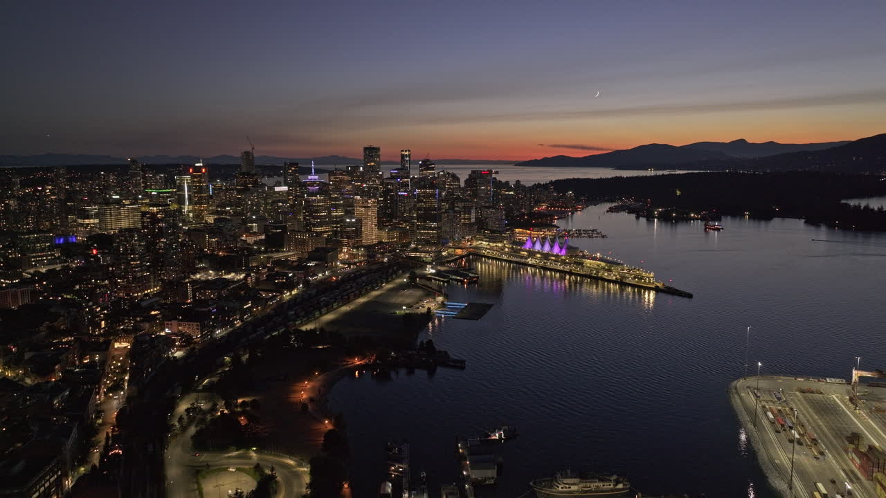 Vancouver BC Canada Aerial v72 cinematic drone flyover the harbour capturing illuminated downtown cityscape at night with sunset dusk sky views - Shot with Mavic 3 Pro Cine - July 2023