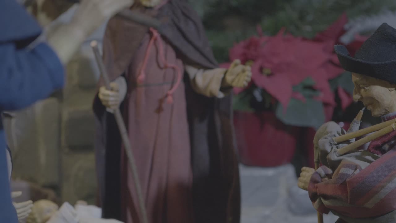 Un pastore suona la cornamusa in un presepe