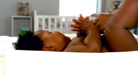 mother changing diaper on the bed