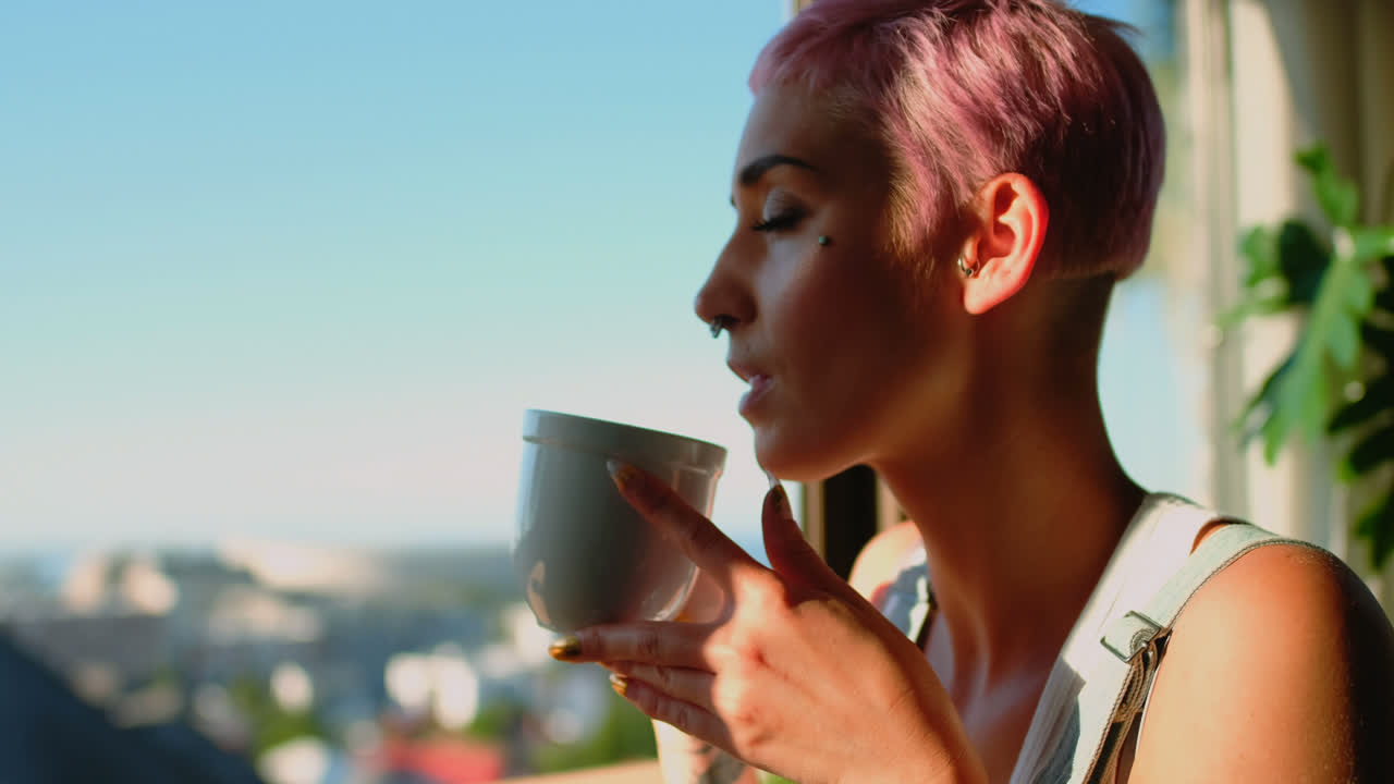 mujer tomando una taza de café y mirando a través de la ventana 4k