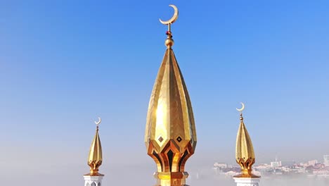 golden minaret of the mosque in close-up against the blue sky