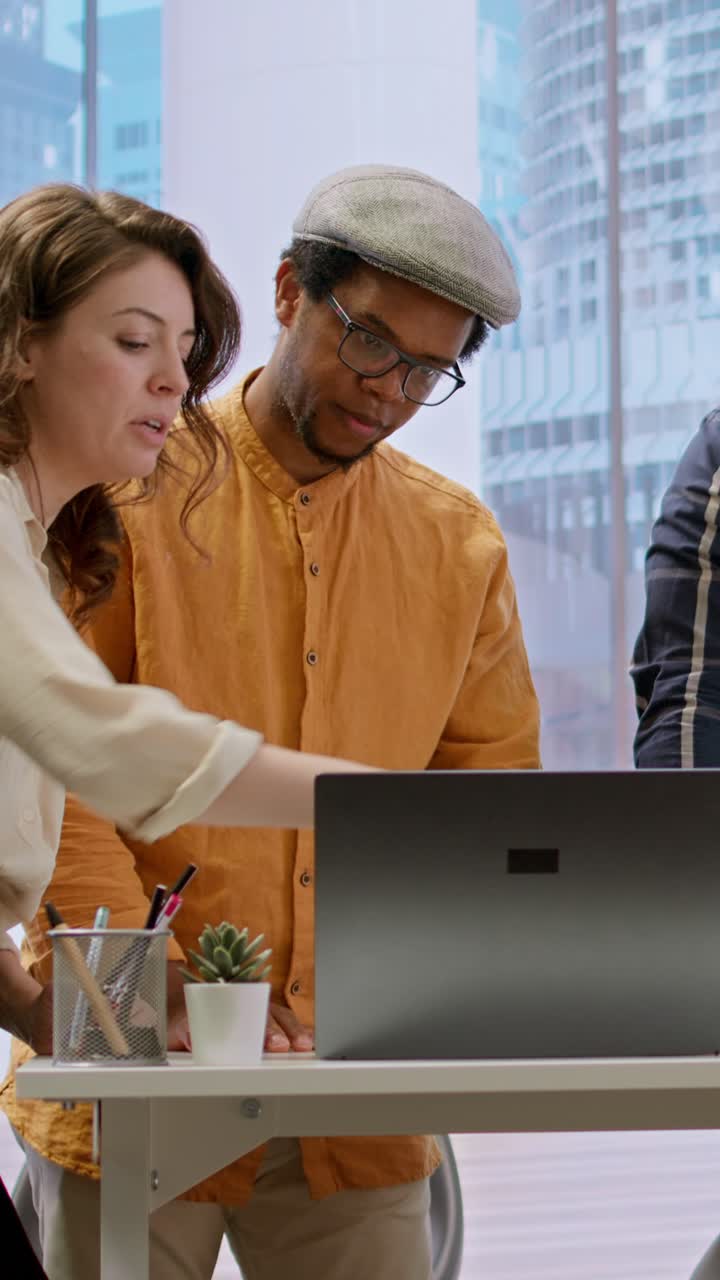 Diverse Business Team Collaborating on Laptop in Modern Office